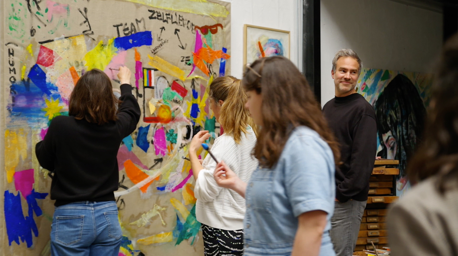 TAUW team members painting and writing together during a shared workshop.